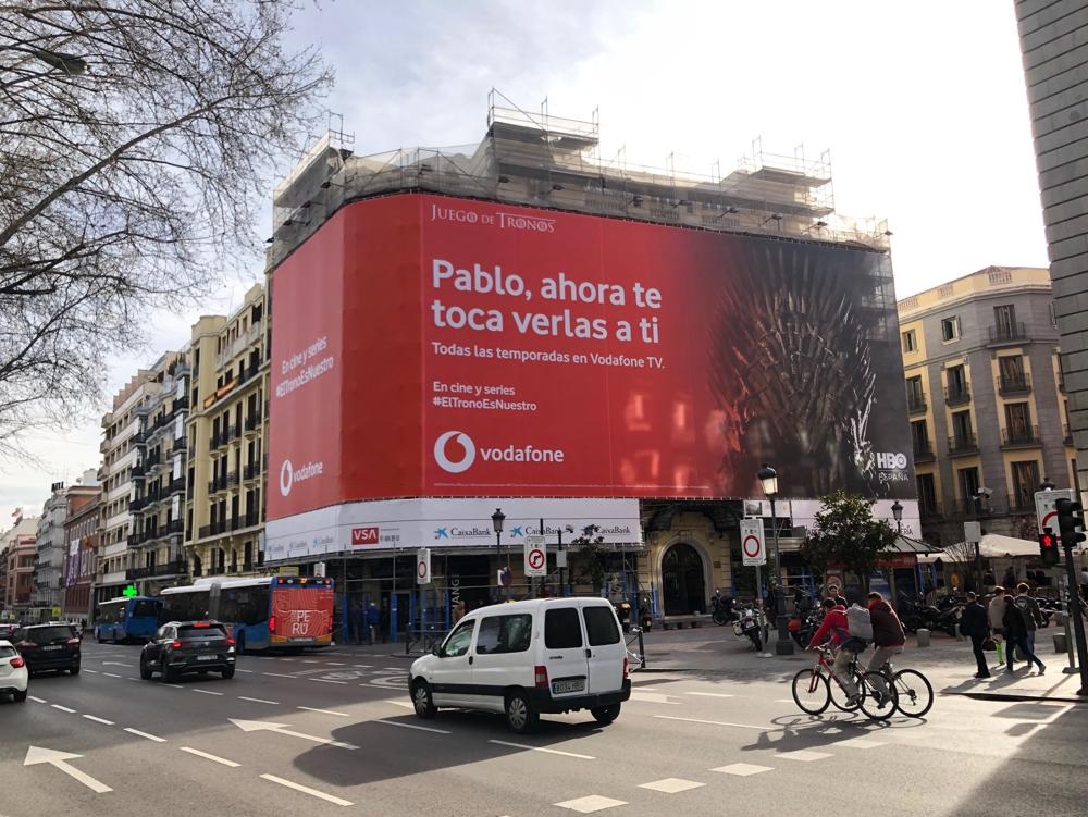 campaña exterior #eltronoesnuestro de Vodafone con Wavemaker. La última campaña de exterior para Vodafone, llamada de wavemaker "Juego de Tronos última temporada” anuncia que del 1 de marzo al 1 de abril de 2019 estará disponible la serie en los paquetes Vodafone con una Lona en un edificio del Paseo del Prado.